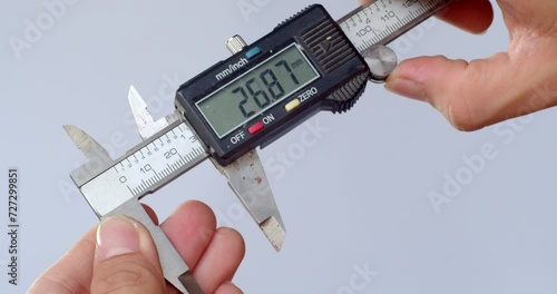 Hand of mechanic holding Vernier Caliper.The hand of the engineer measure digital vernier caliper against the white background