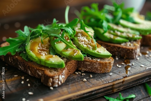Avocado toast for breakfast or lunch with rye bread, sliced avocado, arugula, pumpkin