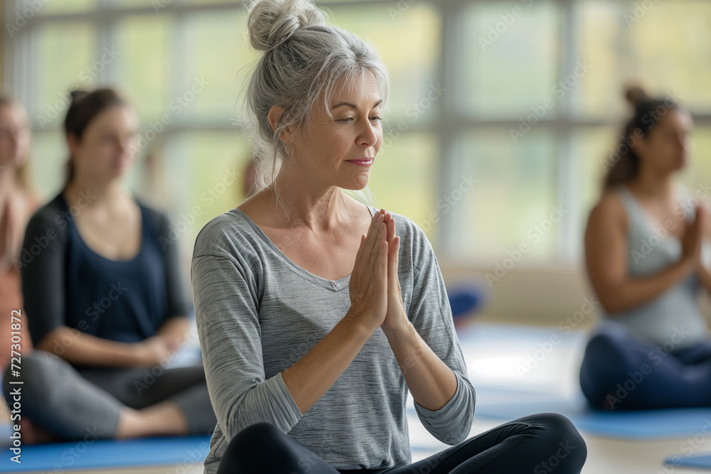 Women do yoga at a group class in the gym.