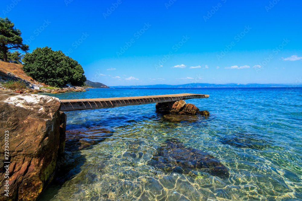 Beautiful scene from wooden pier and turquoise sea.Tarsanas Beach, Thassos, Greece