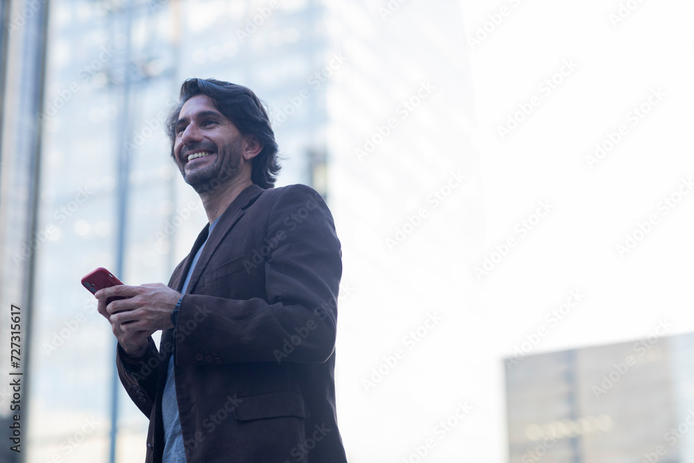 Fototapeta premium View of young man using a smartphone at twilight