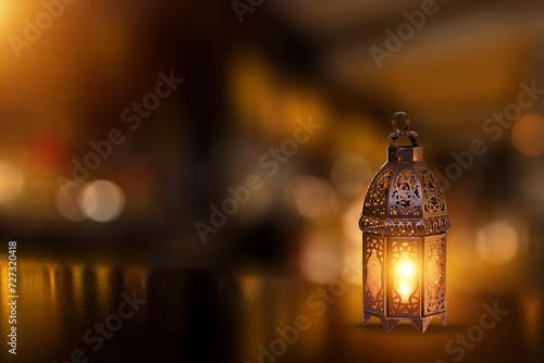 Ornamental Arabic lantern with burning candle glowing . Festive greeting card, invitation for Muslim holy month Ramadan Kareem. Ramadan Kareem greeting photo with serene mosque background. 