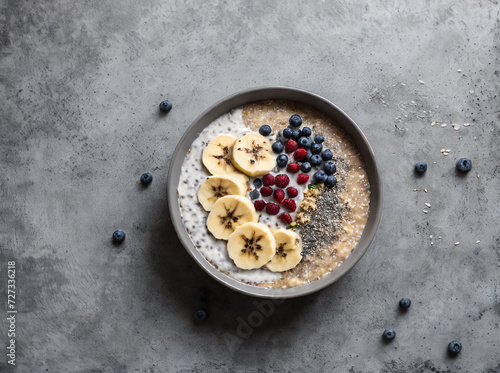 professional detailed photography, Breakfast oatmeal porridge with banana, blueberries, chia seeds on grey concrete background