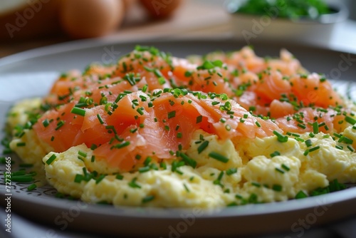 Scrambled eggs with smoked salmon, garnished with chives, a luxurious morning treat.