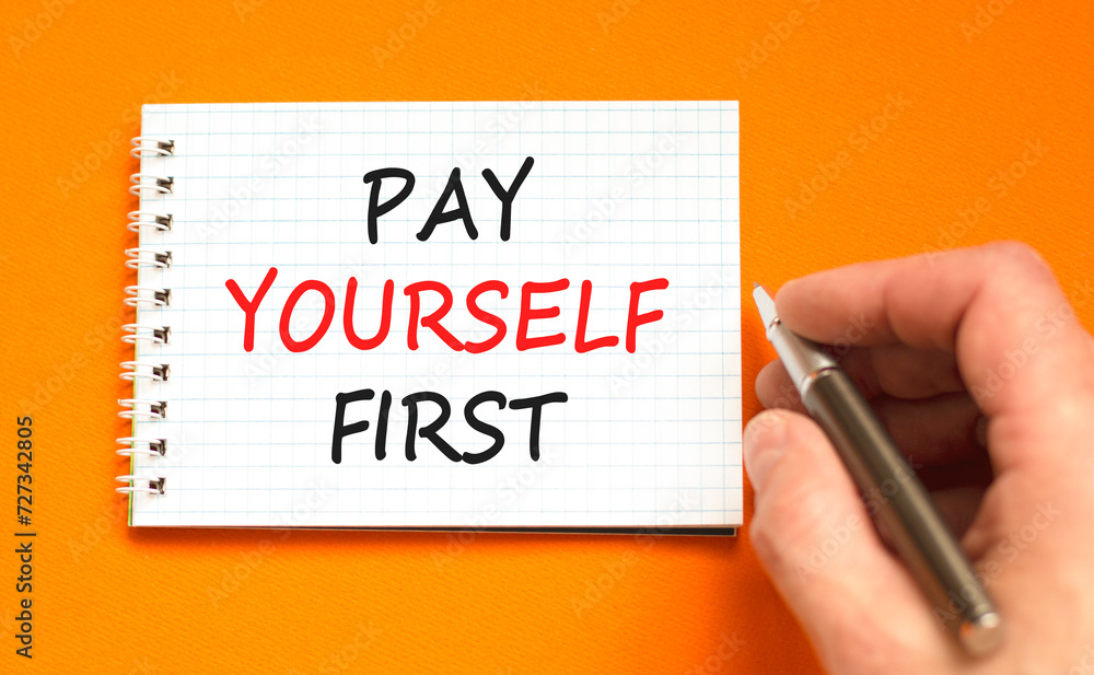 Pay yourself first symbol. Concept words Pay yourself first on beautiful white note. Beautiful orange background. Businessman hand. Business and pay yourself first concept. Copy space. Pay yourself first symbol. Concept words Pay yourself first on beautiful white note. Beautiful orange background. Businessman hand. Business and pay yourself first concept. Copy space.