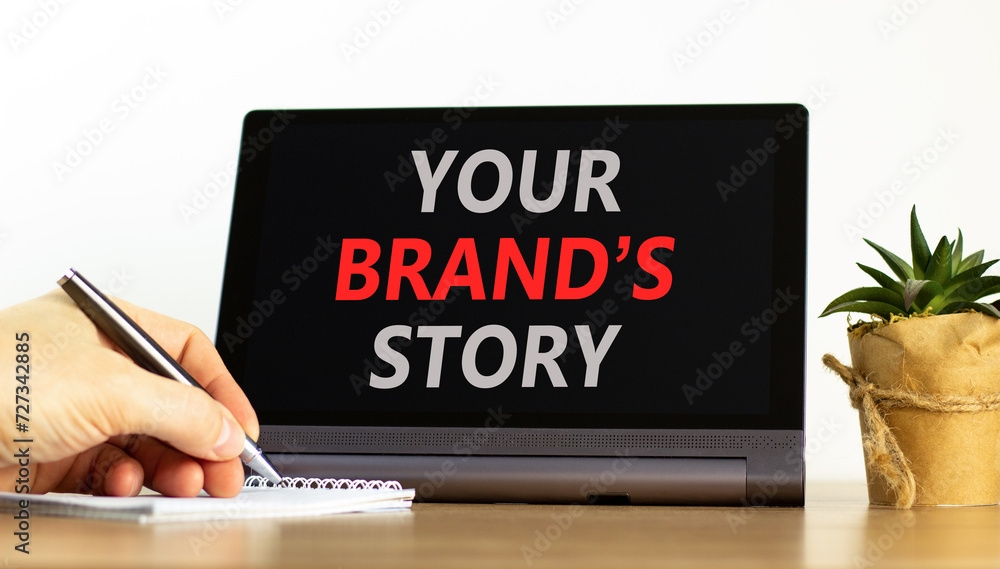 Branding and your brand story symbol. Concept words Your brands story on beautiful tablet screen. Beautiful white background. Businessman hand. Business branding your brand story concept. Copy space.