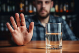 An alcoholic sits at a table with a glass of alcohol, the concept of alcoholism and problems. Background