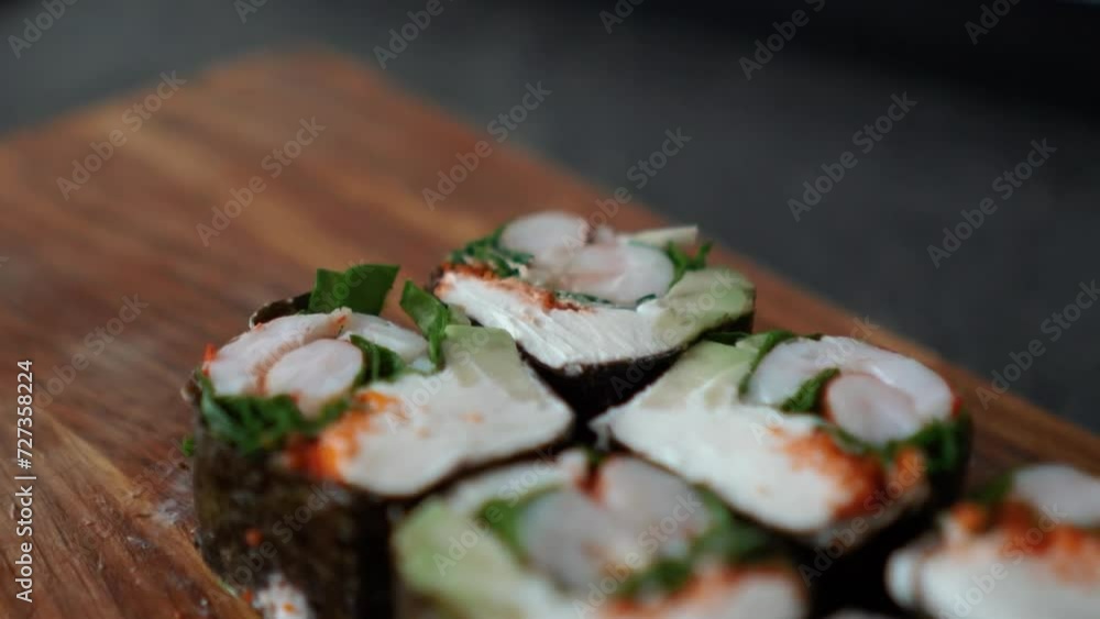 Japanese food with rice, red raw fish, cream cheese, salmon, shrimp, avocado and nori. Appetizing sushi set with rolls on the table. Incredibly tasty and expensive food from a sushi chef Japanese food with rice, red raw fish, cream cheese, salmon, shrimp, avocado and nori. Appetizing sushi set with rolls on the table. Incredibly tasty and expensive food from a sushi chef