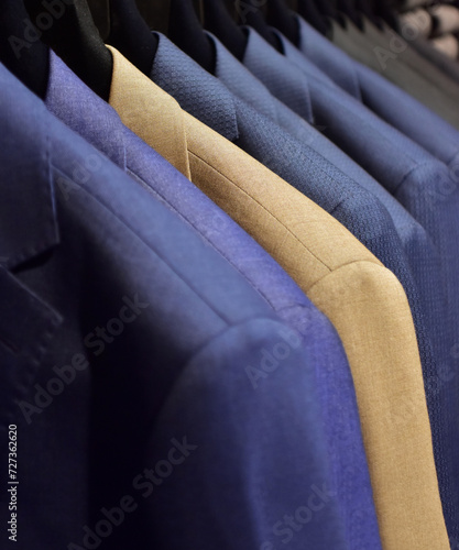 Suits on a clothing hanger in a boutique. 