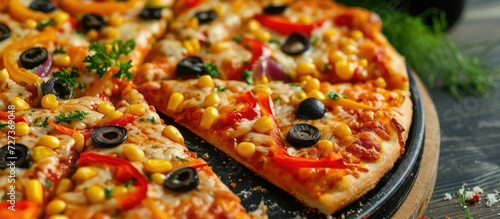 Vegan pizza topped with peppers, olives, and corn.