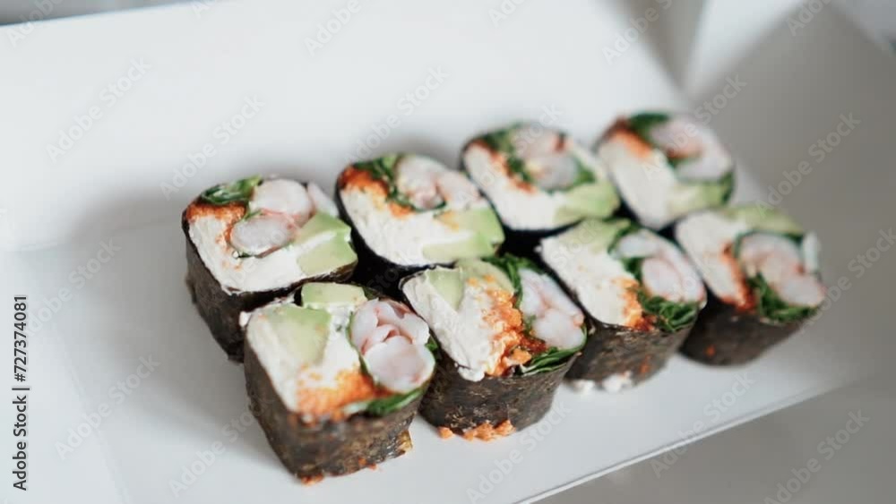 Japanese food with rice, red raw fish, cream cheese, salmon, shrimp, avocado and nori. Appetizing sushi set with rolls on the table. Incredibly tasty and expensive food from a sushi chef Japanese food with rice, red raw fish, cream cheese, salmon, shrimp, avocado and nori. Appetizing sushi set with rolls on the table. Incredibly tasty and expensive food from a sushi chef