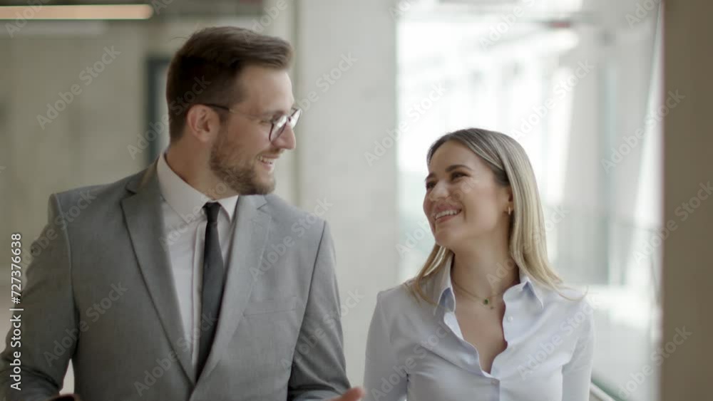 Young business couple holding paper notebook and discussing company strategy Young business couple holding paper notebook and discussing company strategy