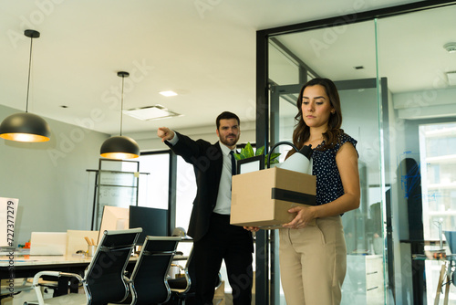 Valokuva Hispanic woman getting fired from work and carrying a box of personal belongings