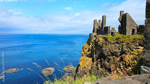 Ruins of the medieval Dunluce Castle overlooking the blue North Atlantic ocean. Causeway Coast, Northern Ireland.