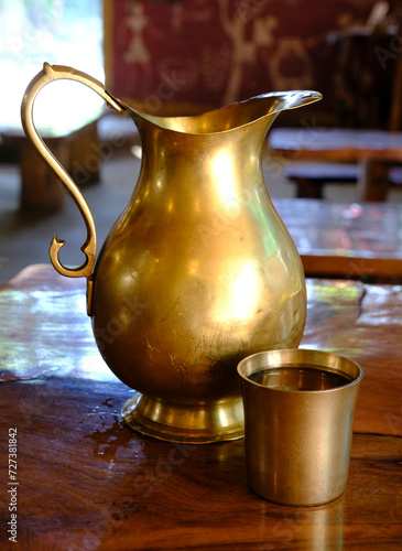 Brass water jug and glass filled with water