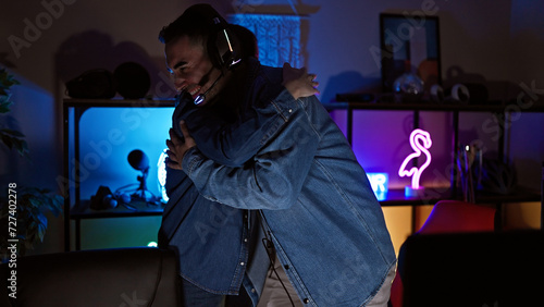 A man and woman embrace happily in a cozy gaming room lit by led lights during evening hours.