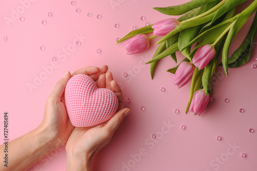 soy handmade candle in the hands of a woman with tulips, a beautiful gift and wish for lovers on Valentine's Day or Mother's Day