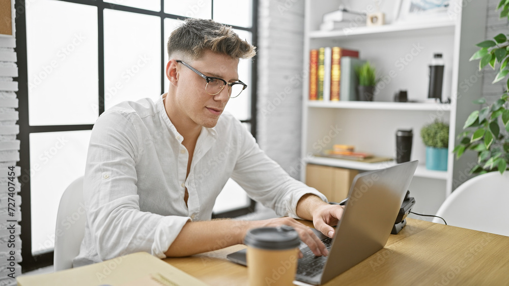 Handsome young caucasian man, focused business worker, effortlessly rocking adult beard, conquering success online, getting serious amid office room's interior, laptop working at sleek desk. Handsome young caucasian man, focused business worker, effortlessly rocking adult beard, conquering success online, getting serious amid office room's interior, laptop working at sleek desk.