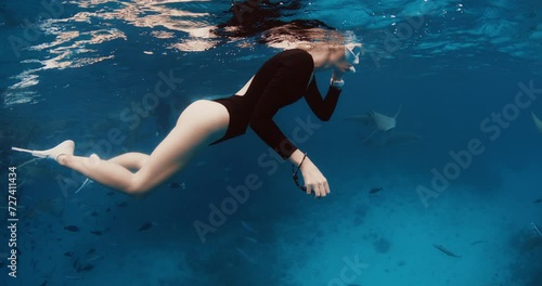 Woman freediver resting on the surface and dive to the deep in a tropical blue sea at Maldives photo