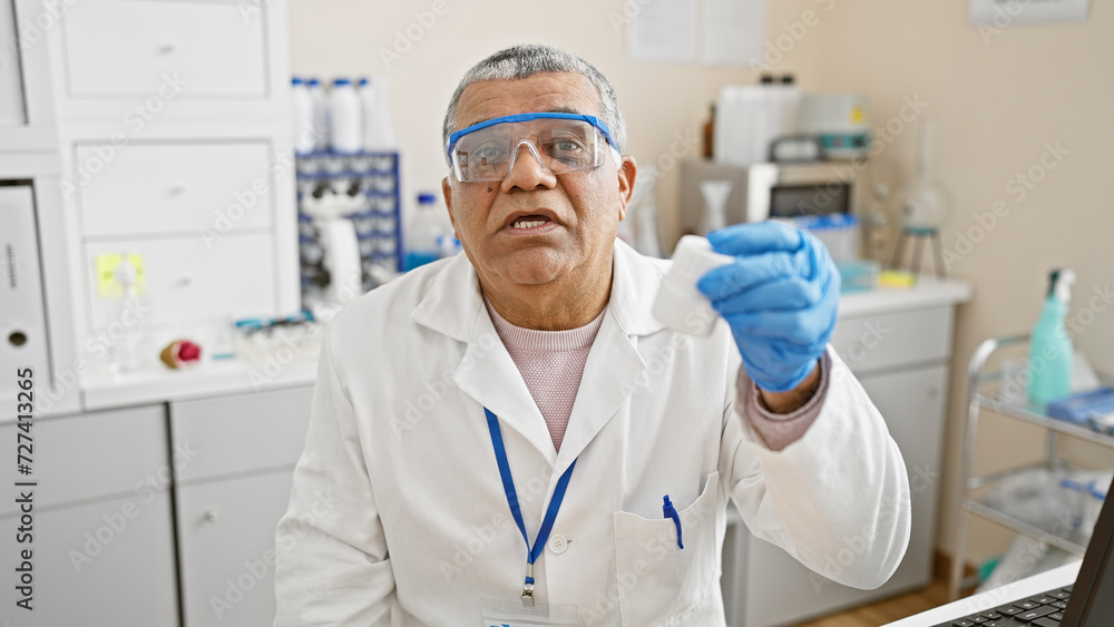 Mature grey-haired man in lab coat and gloves analyzing a sample in a laboratory setting, portraying healthcare and scientific research themes. Mature grey-haired man in lab coat and gloves analyzing a sample in a laboratory setting, portraying healthcare and scientific research themes.