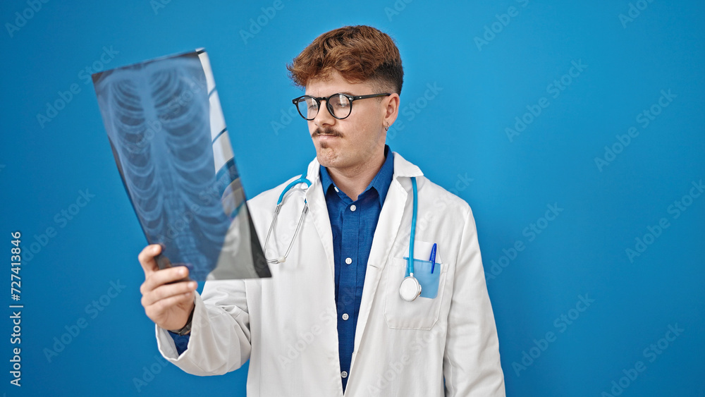Young hispanic man doctor looking xray over isolated blue background Young hispanic man doctor looking xray over isolated blue background