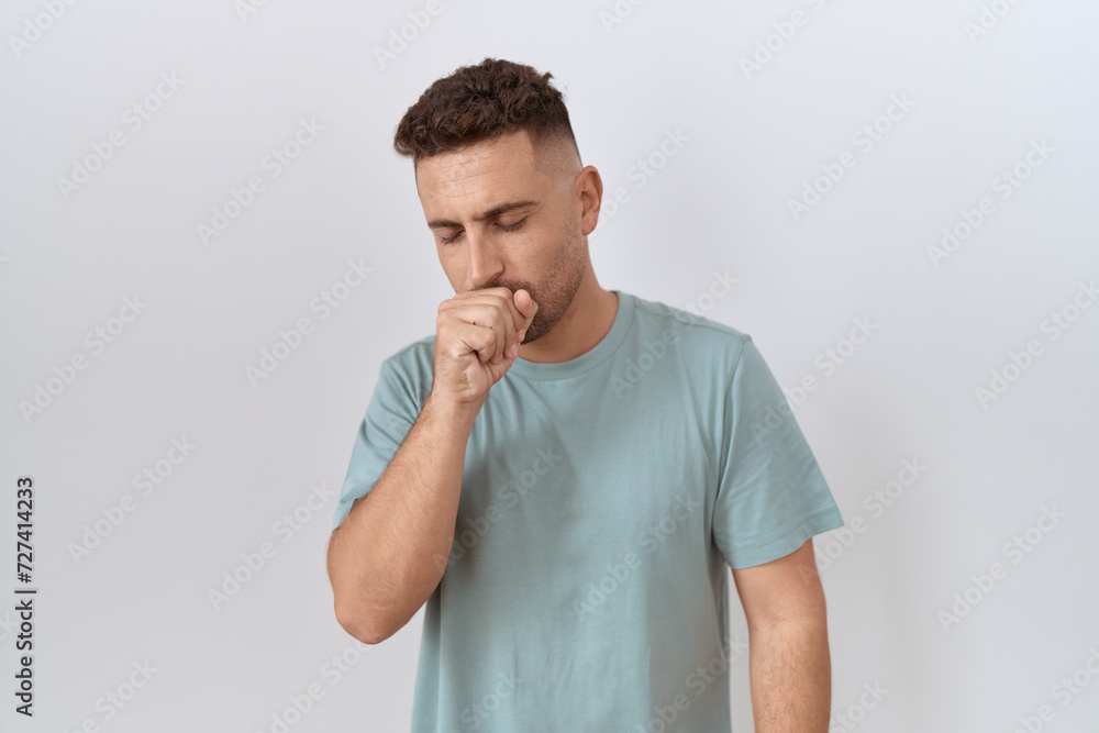 Hispanic man with beard standing over white background feeling unwell and coughing as symptom for cold or bronchitis. health care concept. Hispanic man with beard standing over white background feeling unwell and coughing as symptom for cold or bronchitis. health care concept.