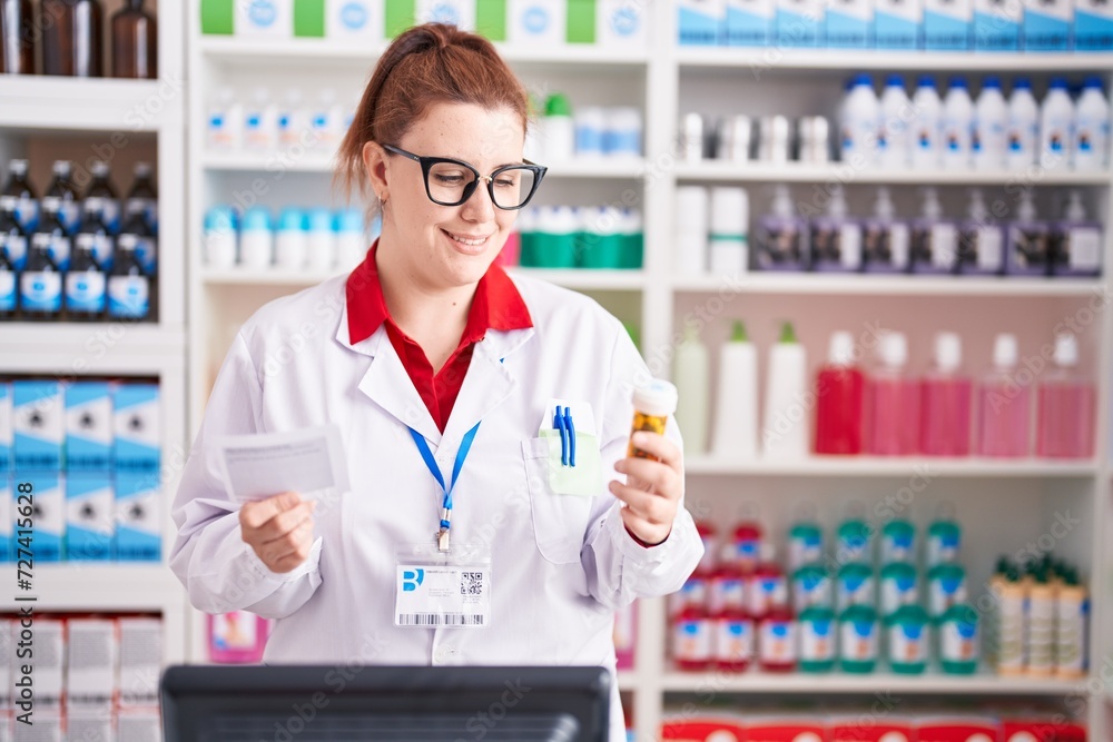 Young beautiful plus size woman pharmacist holding pills bottle reading prescription at pharmacy