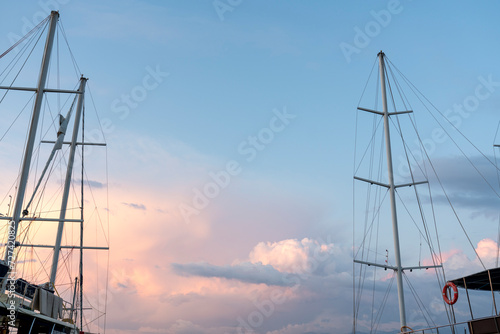 The mast of a sailing ship against a clear blue sky. Ropes, rope ladders and other gear are visible. photo