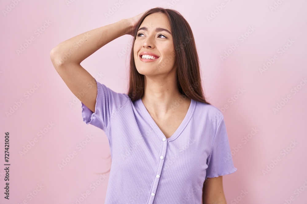 Young hispanic woman with long hair standing over pink background smiling confident touching hair with hand up gesture, posing attractive and fashionable Young hispanic woman with long hair standing over pink background smiling confident touching hair with hand up gesture, posing attractive and fashionable
