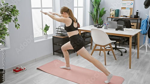 A woman stretching in a modern office space implies a healthier work-life balance.