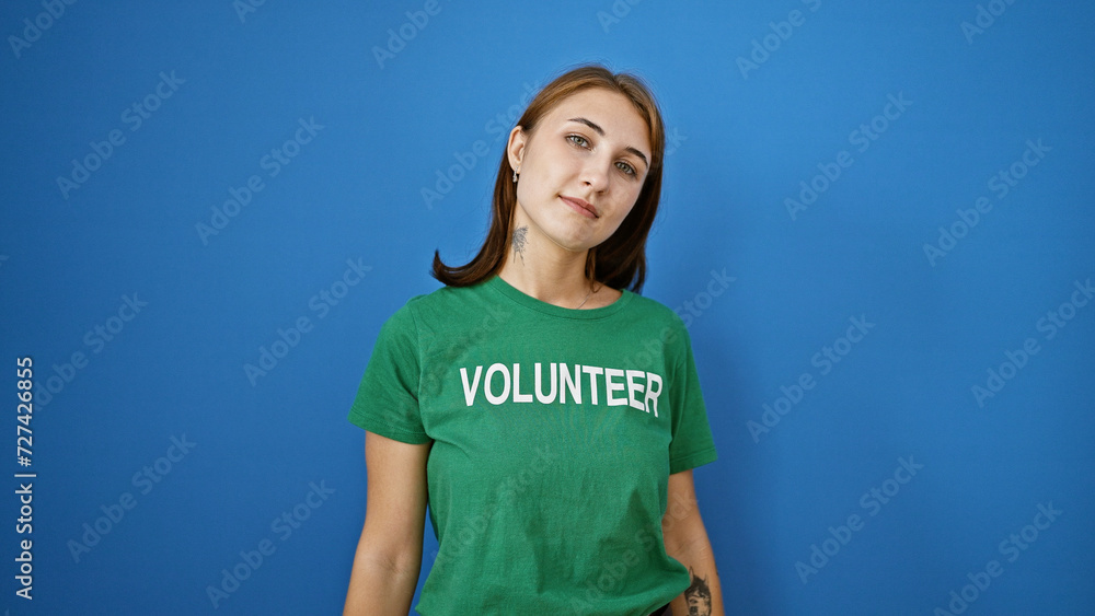 Young woman volunteer standing with serious face over isolated blue background Young woman volunteer standing with serious face over isolated blue background