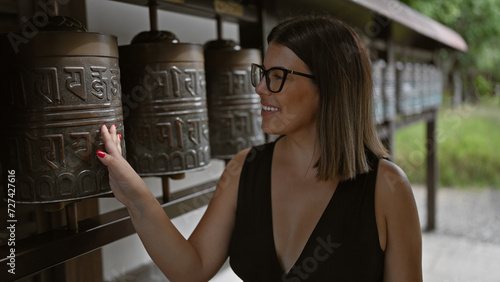 Fotografie Touching spirituality, beautiful hispanic woman rolling prayer wheels at kodaiji
