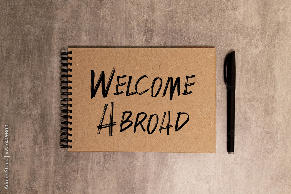 Obraz premium WORKING ABROAD text written on yellow paper with notebook