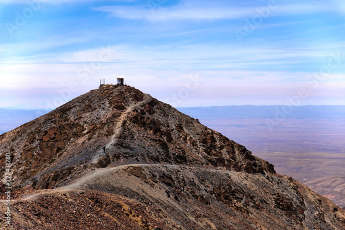 a lone bench on the top of a mountain peak in the desert