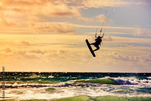 Kite surfer riding waves. Kiteboarding sport.