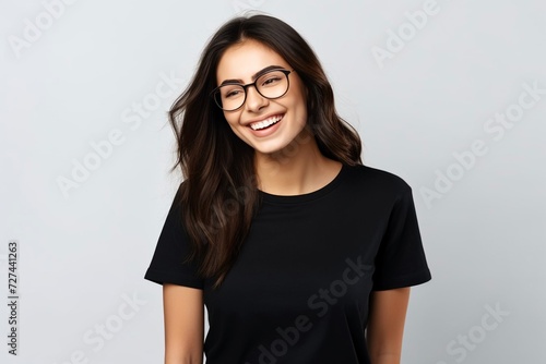 Photo of pleasant looking cheerful woman points index fingers at toothy smile shows wwell cared whie even teeth dressed in casual black t shirt isolated over whtie studio background feels happy  photo