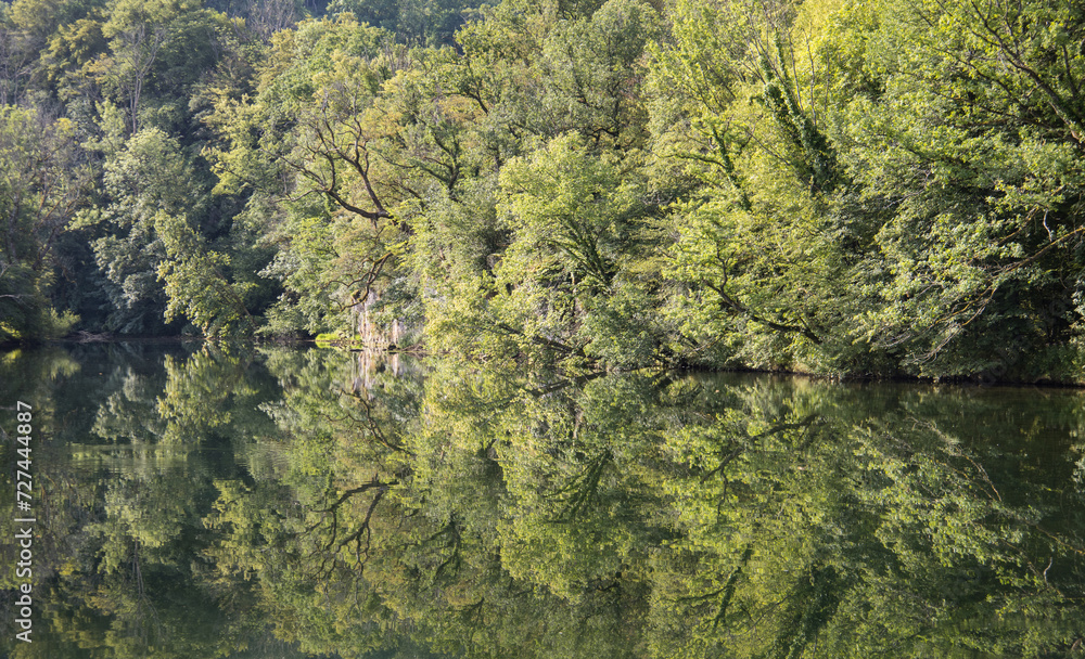 arbres se reflétant dans la rivière la Loue dans le département du Doubs en Franche comté en été arbres se reflétant dans la rivière la Loue dans le département du Doubs en Franche comté en été