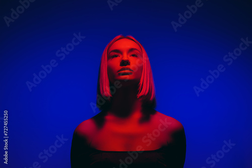 A woman stands enveloped in a serene blue neon light  her silhouette casting a mysterious aura