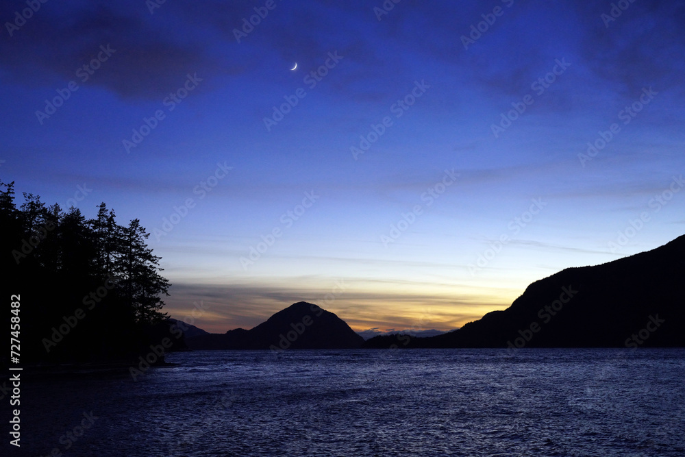 Howe Sound at dusk in winter with a crescent moon high in the sky