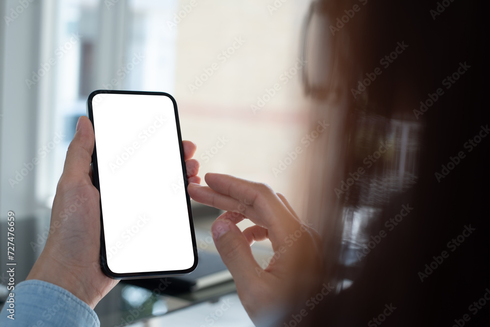 Cell phone blank screen mockup. Woman hand holding,  using mobile phone on desk at office.background empty space for advertise. Social media marketing, website template