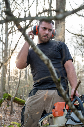 bucheron en plein travail dans une forêt avec un casque anti bruit connecté photo