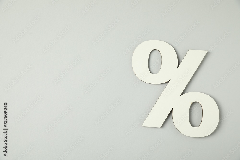 White percent sign on light grey background, top view. Space for text White percent sign on light grey background, top view. Space for text