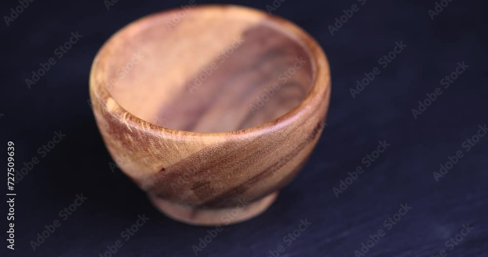 an empty wooden bowl on a black slate table, a black background and a wooden food bowl an empty wooden bowl on a black slate table, a black background and a wooden food bowl