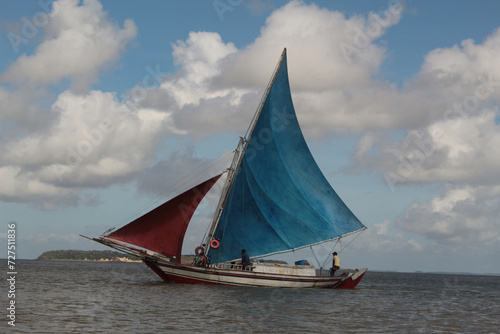 Rustic wooden sailboat, traditional from Maranhão, sailing at the mouth of the Anil River, in São Luís, MA. Traditional sailboat, colorful sails, open sea.