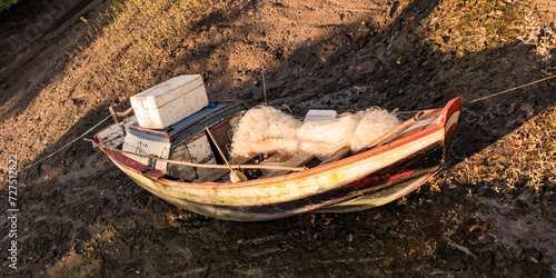 A small traditional fishing boat, typical of the state of Maranhão, Brazil, has a fishing net on the deck photo