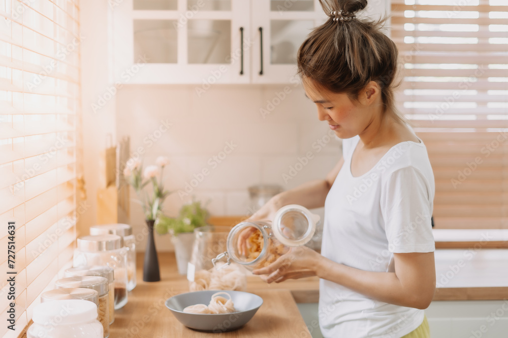 Asian woman preparing breakfast in the kitchen in the morning.