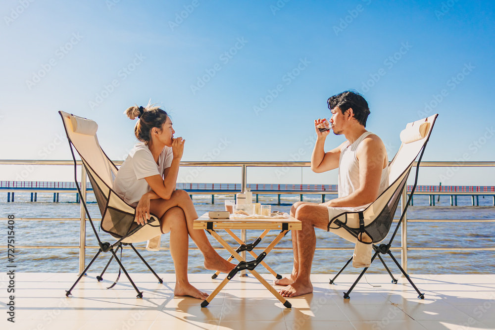 Asian couple lover enjoy their holiday at the sea in the summer with beautiful clear sky ocean.