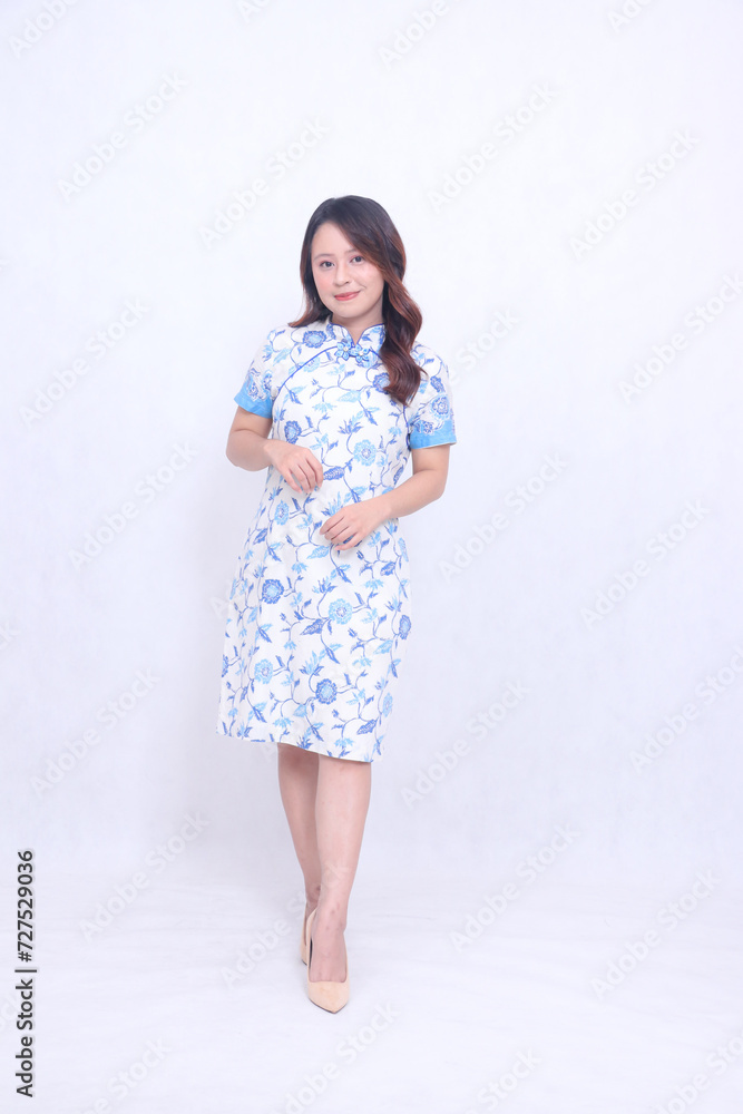 Young elegant Asian woman wearing modern chinese dress formal standing pose isolated on white background. happy Chinese New Year Young elegant Asian woman wearing modern chinese dress formal standing pose isolated on white background. happy Chinese New Year