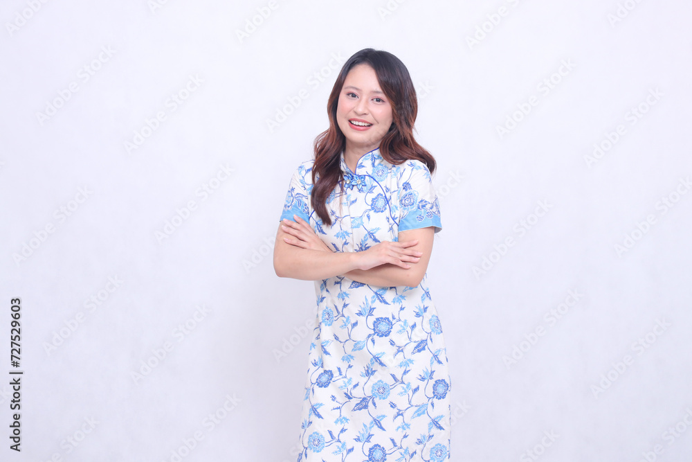 Beautiful Indonesian woman laughing wearing a modern Chinese dress with her arms crossed isolated on a white background. happy Chinese New Year Beautiful Indonesian woman laughing wearing a modern Chinese dress with her arms crossed isolated on a white background. happy Chinese New Year