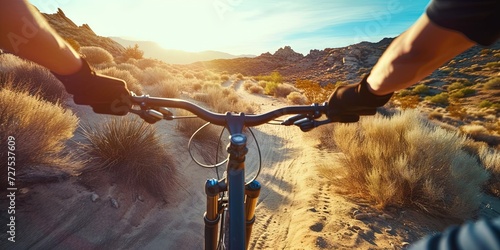 Cyclist riding BMX bike on dirt trail in desert landscape